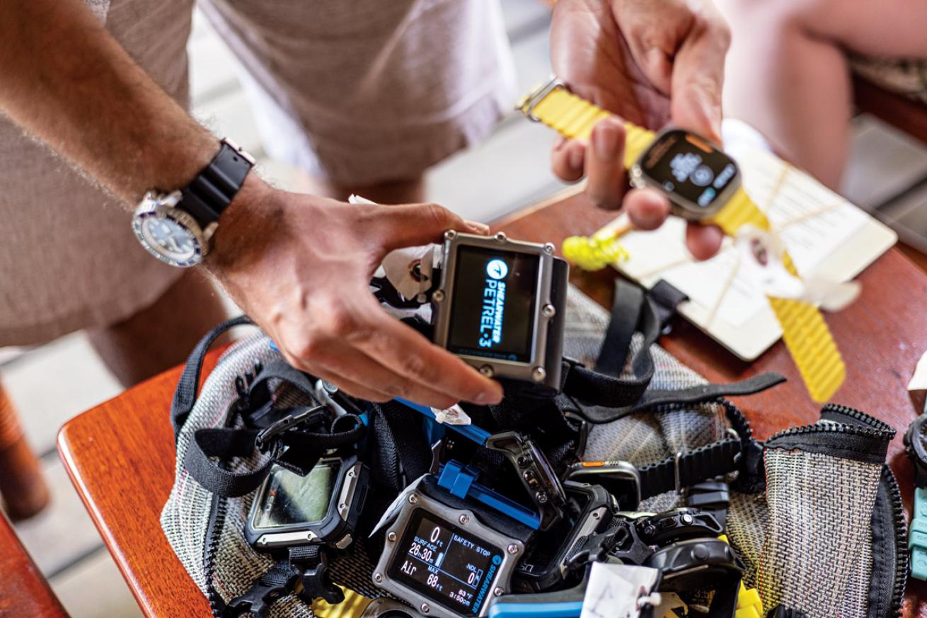 a pile of scuba diving computers