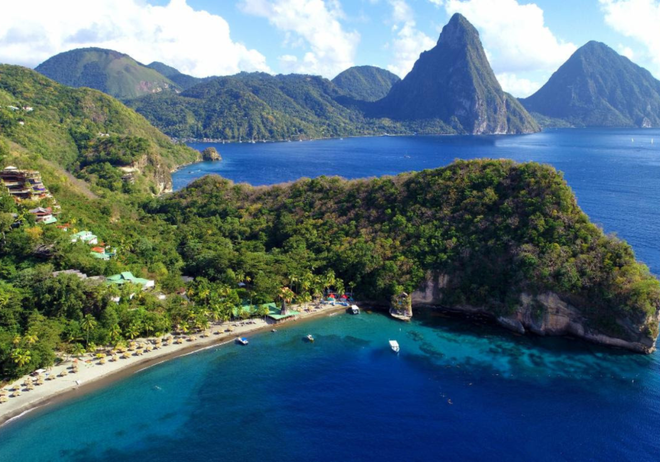 A beach with trees and mountains in the background with Anse Chastanet in the background